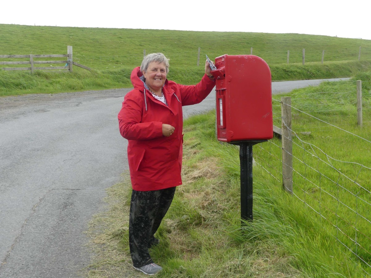Susan a tour guest posting a letter in the most northerly post box in the UK